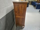 a tall wooden cabinet in the middle of a room