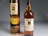 un gros plan sur une bouteille de whisky posée à côté d'une boîte en carton