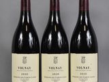 trois bouteilles de vin rouge posées sur une table