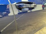 a close up of a car door handle with a reflection of a man in the mirror
