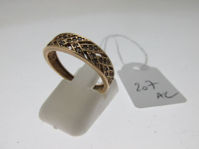gros plan d'une bague sur une surface blanche avec une étiquette de prix