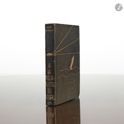 un vieux livre posé sur une table à côté d'un mur blanc