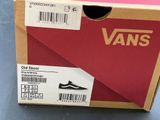 vans old skool shoes in a box on a blue surface