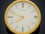 a gold clock with roman numerals on the face