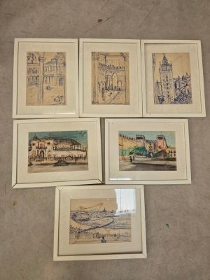 six dessins encadrés représentant des bâtiments et une voiture sont posés par terre