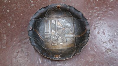 une plaque métallique sur laquelle figure une image, posée par terre