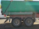 a green dump truck that is parked in the dirt