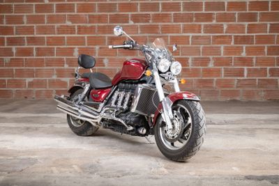 a red motorcycle that is parked in front of a brick wall