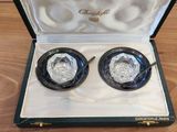 paire de boucles d'oreilles en verre argenté et noir, présentées dans un écrin