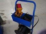 un chariot bleu posé par terre, contenant des outils