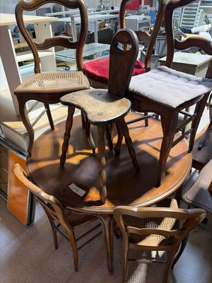 several chairs and a table in a room with a lot of windows