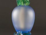 a glass vase with a green leaf on it