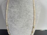 un collier composé de perles et de perles en or sur un mannequin