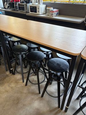 tables and stools are lined up in a restaurant with a laptop on the counter