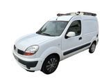the small white van is parked on the side of the road