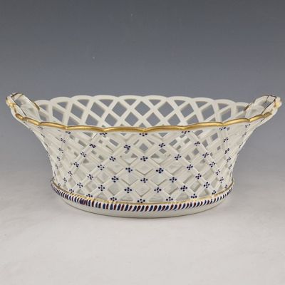 a white and blue basket with a gold rim
