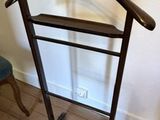 a coat rack with a hanger on it in the corner of a room