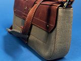 a brown and tan purse on a blue surface