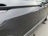 a black car parked on the side of the street