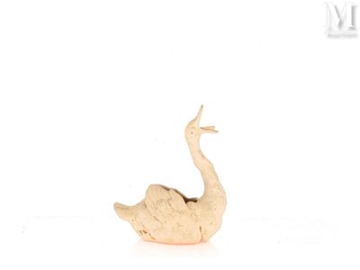 une petite statue représentant un oiseau posée sur une surface blanche