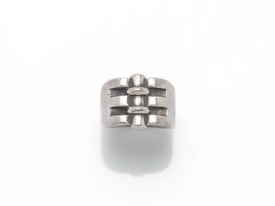 gros plan d'une bague en argent sur une surface blanche