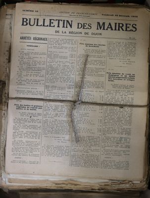 an old newspaper with a cross on top of it sitting on top of a table
