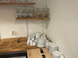a small kitchen with a lot of dishes and cups on the counter