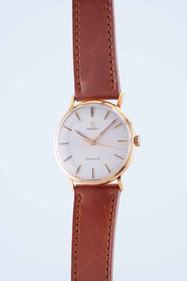 a close up of a watch on a white surface with a brown strap