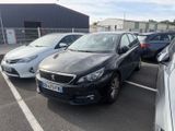 Plusieurs voitures sont garées sur un parking situé devant un immeuble.
