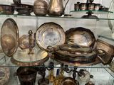 une vitrine en verre contenant de nombreux objets en argent