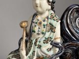 a figurine of a woman sitting on a bench