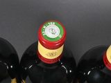 three bottles of wine are lined up on a table