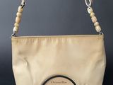 a close up of a beige purse with a beaded handle