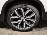 the wheel of a white bmw suv parked in a parking lot