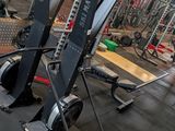 a gym with a row of machines in the middle of the room