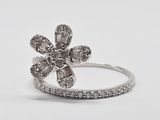un gros plan d'une bague en forme de fleur sertie d'un diamant, sur fond blanc