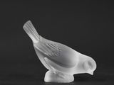 black and white photograph of a glass bird on a black surface