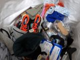 a bag full of clothes and shoes on a bed