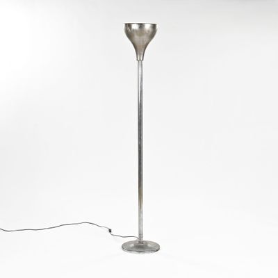 un lampadaire argenté avec un pied en métal et un fond blanc