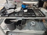several trays of assorted metal items sit on a metal shelf