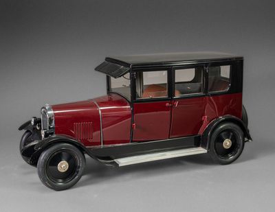 une maquette de voiture rouge posée sur une surface grise
