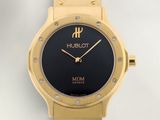 gros plan d'une montre sur une surface blanche avec un bracelet noir