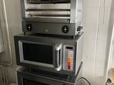 trois micro-ondes empilés les uns sur les autres dans une cuisine