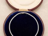 a diamond necklace in a velvet case on a table