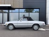 an image of a silver convertible car parked in front of a building