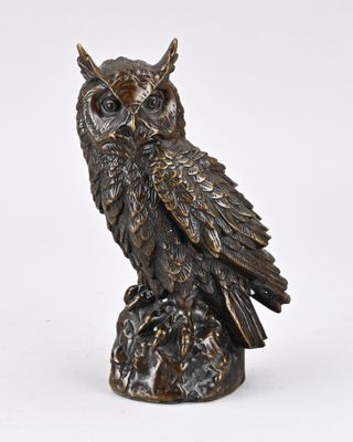 statue en bronze représentant un hibou perché sur un rocher, sur fond blanc