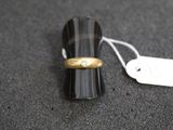 une bague en or sertie d'un diamant, à côté d'une étiquette de prix