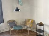 a room with a table, chairs, and a birdcage in it