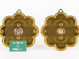 pair of gold plated medallions with red and white stones on them