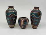 trois vases posés l'un à côté de l'autre sur une surface blanche
